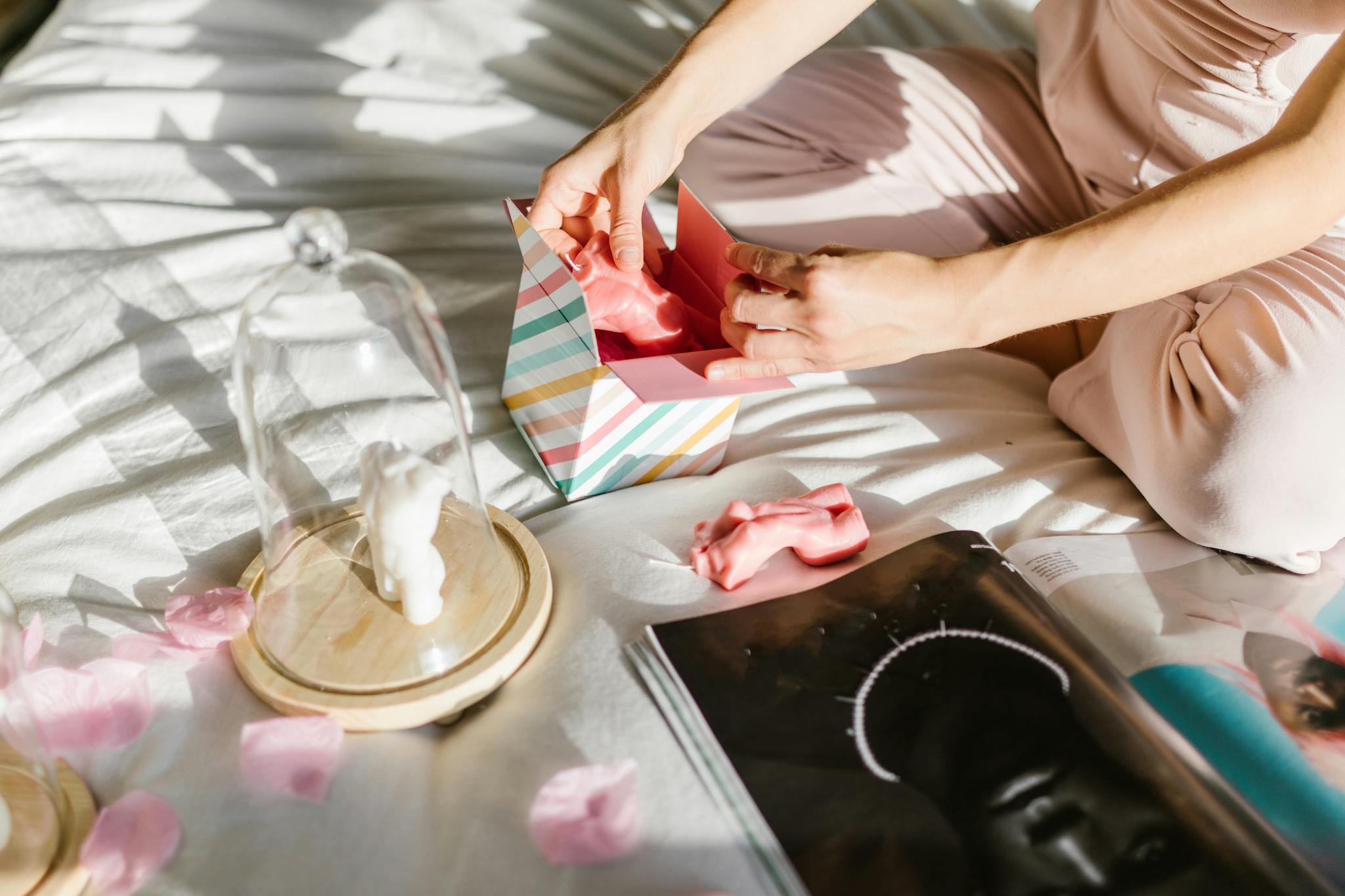 FAQ A person unboxes a gift among pink petals, promoting elegance and luxury.